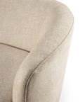 A close-up of the Ellipse Sofa - Oatmeal by Ethnicraft highlights its modern, curved design with a smooth backrest and armrests, upholstered in textured beige fabric for an elegant, contemporary look.