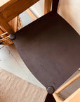A close-up of the SOBU Frank Counter Stool in black ash stands beside a light wood table and woven basket on a light floor, with part of a beige rug visible in the lower left corner.