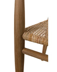 Close-up of the Finley Chair by Noir Trading Inc., featuring a teak leg and frame with a woven rattan seat, highlighting the texture and craftsmanship of natural materials from our hand-crafted collection against a white background.