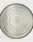 The Gold Beads Mirror Tray (Round/Large) by Ethnicraft features concentric circles of gold beads on a light background, creating a ripple-effect pattern reminiscent of tribal designs. The tray is finished with a thin dark rim.