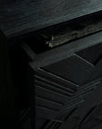 A close-up of the Ethnicraft Graphic Dresser highlights its dark geometric design, with the top drawer partially open to reveal a textured fabric inside.
