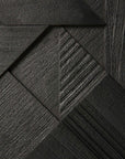 Close-up of a dark, textured geometric pattern formed by interlocking wood-like panels in varied grain, inspired by the Ethnicraft Graphic Sideboard - 3 door for a modern and angular design.