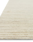 A close-up of the Loloi Hadley Rug - Ivory showcases its beige, textured surface with horizontal ribbed lines and refined hand-cut pile, set against a white background.