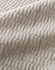 Close-up of the Hadley Rug - Oatmeal by Loloi, showcasing its beige, ribbed, corduroy-like texture with soft, parallel raised lines—loom-knotted for subtle dimension and gentle folds.