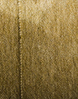 A close-up of the Radhi Rug - Moss by HIMALAYAN HERMITAGE, showing its textured olive-green surface and central seam beside a brown wooden surface.
