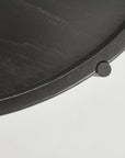 Close-up of the Humla Round Side Table by Wooden Stories, showing its dark wood edge with a raised rim and small cylindrical knob, crafted in Danish design style, set against a plain white background.