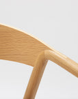 Close-up of the Wooden Stories Inlay Dining Chair | Light Oak, featuring a smooth plywood backrest and angled solid wood arms in a light natural oak finish, set against a plain white background.