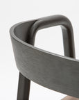 Close-up of the backrest and upper frame of the Wooden Stories Inlay Dining Chair in Black Oak and Leather, showing smooth curves and a plywood backrest against a plain white background.