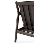 Close-up of the Ethnicraft Jack Lounge Chair - Black Leather, highlighting its dark wooden slatted backrest and angled legs in a Scandinavian modernist style, set against a white background.