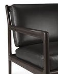 Close-up of the Ethnicraft Jack Lounge Chair in black leather, featuring a dark wooden frame and minimalist Scandinavian-inspired design with clean lines and smooth surfaces.
