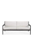 The Ethnicraft Jack Outdoor 2 Seater Sofa features a sleek black teak frame and off white cushions. Its minimalist design includes straight armrests and legs, shown against a plain white background.
