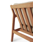Close-up of the back of the Ethnicraft Jack Outdoor 2 Seater Sofa - Teak with Natural, featuring angled slats and light-colored cushions. Crafted from Grade A teak, the wood has a smooth, natural finish.