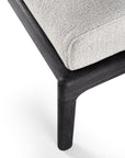 Close-up of the Ethnicraft Jack Outdoor Footstool, featuring a dark FSC-certified black teak frame and leg with an off-white textured upholstered cushion, set against a white background.