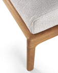Close-up of the Jack Outdoor Footstool by Ethnicraft, featuring a Grade A Teak frame and leg supporting an upholstered off white cushioned seat. The design is modern and minimalistic.