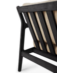 Close-up of the Ethnicraft Jack Outdoor Lounge Chair in black FSC-certified teak with a natural textured cushion, set against a white background.