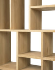 Close-up of Ethnicrafts M Rack Short - Oak, a Mondrian-inspired solid oak shelving unit with open rectangular compartments in various sizes and a light natural wood finish. Shelves are empty against a plain white background.
