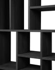 The Ethnicraft M Rack Tall - Black is a dark wooden shelving unit with rectangular open compartments in an asymmetrical grid, crafted from European oak with a sleek black varnish and photographed empty against a white background.