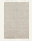 The Malawi Rug - Oatmeal by Armadillo&Co is a rectangular, light beige woven rug with subtle horizontal stripes and short tassels on the edges, lending an artisanal touch to your space.