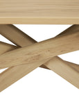 Close-up of the base of the Ethnicraft Mikado Dining Table Rectangular - Oak, featuring intersecting light European oak beams with a smooth, natural finish.