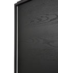 Close-up of the Monolit Sideboard - 2 door by Ethnicraft, showing the edge of its solid European oak black wooden panel with visible grain texture, framed by a sleek black metal border and detailed surface.
