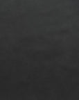 Close-up of a dark, textured surface from Wooden Stories' Fabric + Leather Swatches. The material has a black leather look with subtle grain and a matte finish, ideal for custom made-to-order pieces or selecting fabric swatches.