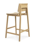 The N3 Counter Stool by Ethnicraft features a minimalist solid oak design with a rectangular seat, angled backrest, clean lines, natural finish, four legs, and a supportive footrest.