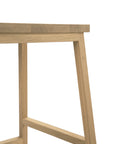 A close-up of the Ethnicraft N3 Counter Stool - Oak highlights its smooth rectangular top and angled legs with crossbars, set against a plain white background.