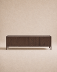 The Wooden Stories Nell Sideboard | Espresso Oak is a rectangular, dark wood sideboard featuring four cabinet doors and short legs, crafted from solid oak in an understated Scandinavian design, set against a plain beige background.