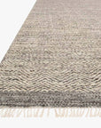 A close-up of the Loloi Omen Rug - Grey shows its hand-woven chevron pattern and fringed edges, displayed against a white background.