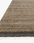 A close-up of the Loloi Omen Rug - Mocha, a rectangular hand-woven jute rug with brown and beige zigzag patterns and white fringe tassels, shown on a plain white background.