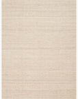 The Omen Rug - Natural by Loloi is a rectangular, hand-woven jute rug in light beige with subtle texture and short fringe on the edges, shown against a white background.