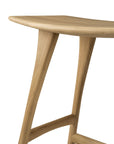 A close-up of the Osso Counter Stool - Oak by Ethnicraft shows its smooth, rounded edges and slender, angled legs, highlighting its minimalist design.