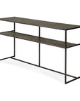The Ethnicraft Pentagon Console - Whiskey is a modern, rectangular table with a black metal frame and two dark, textured surfaces, crafted with mineral powders. Its minimalist design offers clean lines, an open feel, and no visible drawers or cabinets.