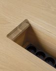 Close-up of the Ethnicraft Geometric Meeting Table - Oak, featuring a rectangular cut-out with a built-in power outlet strip and integrated wire management in the recessed compartment.