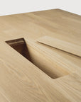 The Ethnicraft Geometric Meeting Table - Oak features a light natural finish and a rectangular cutout with a removable panel, providing integrated wire management.