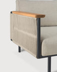 A close-up of the Corbey Outdoor Sofa by Ethnicraft highlights its light wood armrest, black metal frame, beige woven fabric sides, and light beige upholstered seat and back—perfect minimalist elegance for your outdoor space.