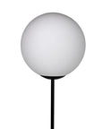 The Lazarus Floor Lamp by Noir Trading Inc. showcases industrial elegance with a spherical white frosted glass shade on a slender black stand, set against a plain white background.