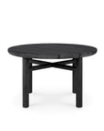 The Quatro Outdoor Side Table 23.5 by Ethnicraft features a round black teak top and sturdy cylindrical legs, offering a simple, modern style to any space. Shown against a plain white background.