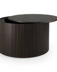 The Roller Max Coffee Table - Mahogany by Ethnicraft is a round, dark wood table with vertical grooves and a lift-top lid revealing hidden storage. The lid is shown partially open.