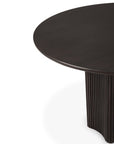A close-up of the Ethnicraft Roller Max Round Dining Table in dark mahogany, featuring a smooth surface and fluted cylindrical base, photographed against a white background.