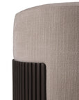 Close-up of Ethnicrafts Roller Max Pouf, a modern beige upholstered ottoman featuring rounded edges and a vertical, ribbed dark wood accent panel. Texture details in both the fabric and wood are clearly visible.