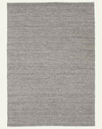 The Sherpa Weave Rug - Pumice by Armadillo&Co is a rectangular, handwoven wool rug in textured gray, displayed on a light background to highlight its minimalist design and subtle variations in shade and weave.