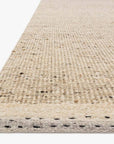 Close-up of the Loloi Sloane Rug - Natural, hand-woven with textured beige and cream tones and subtle speckles, ideal for a contemporary bohemian style, shown against a white background.