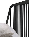 Close-up of Ethnicraft’s Spindle Bed in black oak, featuring solid European oak construction, vertical slats on the headboard, light gray bedding, and a textured beige pillow.