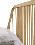 Close-up of the Ethnicraft Spindle Bed - Oak, featuring a wooden slatted headboard in European oak, styled with light bedding and two textured, neutral-toned pillows.