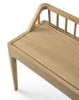 The Ethnicraft Spindle Bench - Oak features a minimalist design with smooth, light solid European oak, clean lines, a slatted backrest, angled armrest, and a modern natural finish.