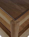 Close-up of the Spindle Nightstand - Teak by Ethnicraft, highlighting the smooth glass-topped corner and layering over FSC-certified teak. Clean lines and superior craftsmanship showcase its modern design.