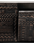 Close-up of the Ethnicraft Tabwa TV Cupboard - 94, showcasing dark wooden surfaces with intricate, hand-carved linear geometric motifs that give a textured and decorative look inspired by Ethnicrafts signature design.