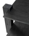Close-up of the Ethnicraft Teak Abstract Side Table, showcasing its modern black wooden design with thick legs and two rectangular shelves. The visible wood grain highlights its European refinement from an angled top-down view.