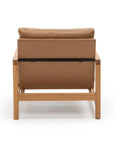 The Troubadour Lounge Chair by Wooden Stories features light brown leather upholstery and a solid light oak frame, showcasing Danish-inspired design. Shown from the back against a plain white background.